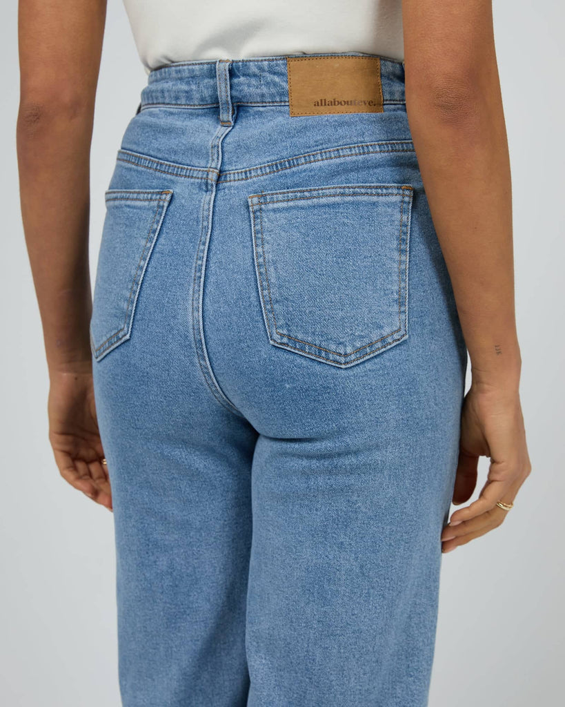 Blue jeans with a visible brand label on a plain background