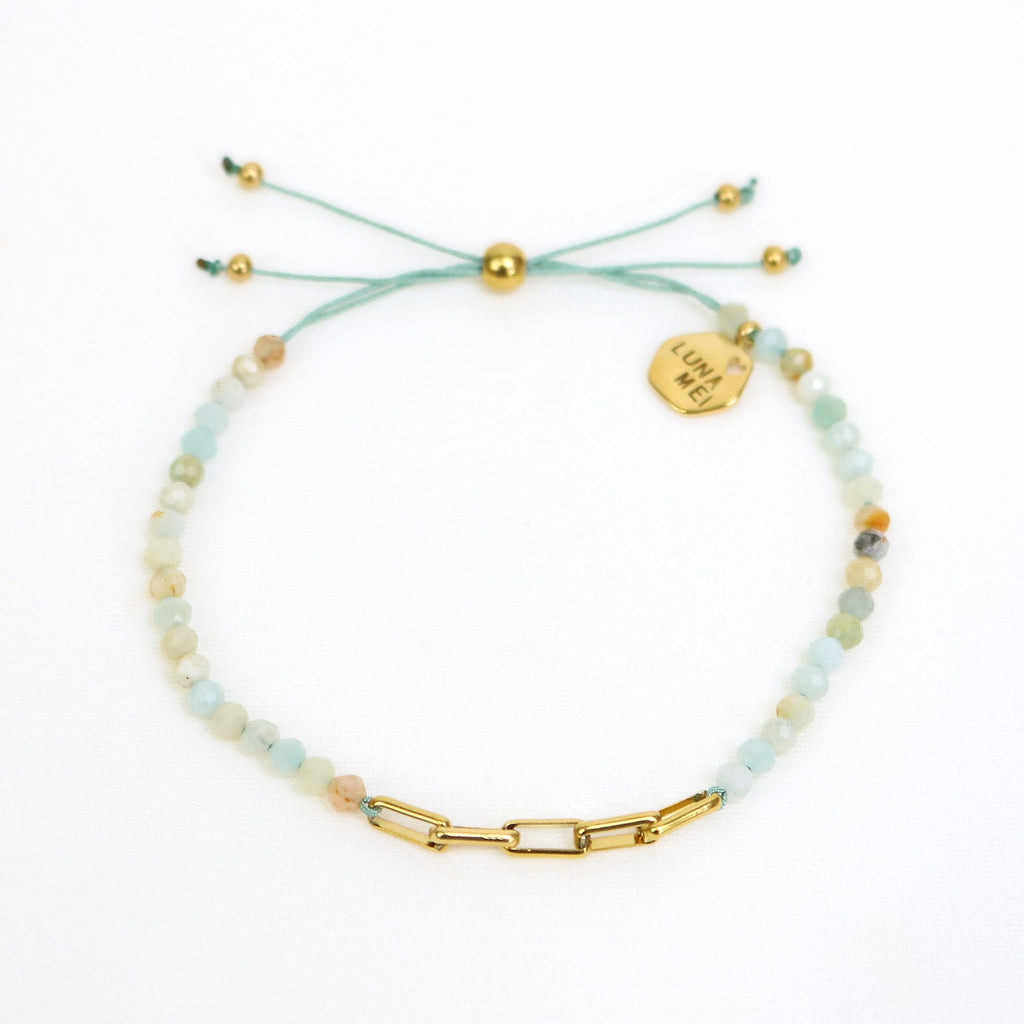 Bracelet with beads and gold chain on a white background