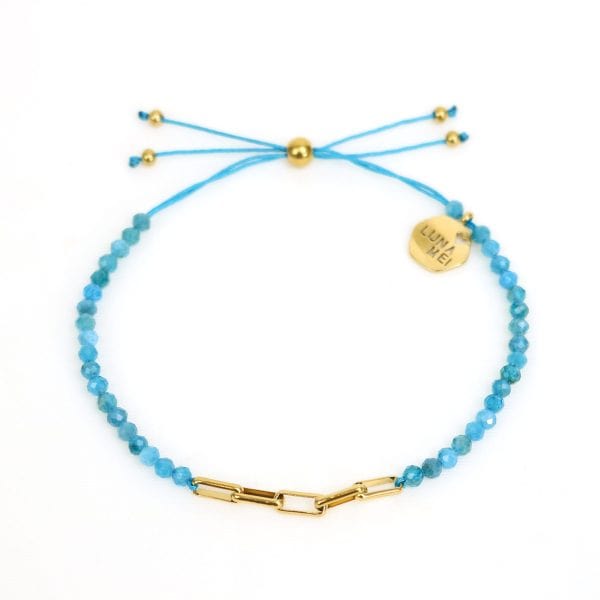 Blue beaded bracelet with gold accents on a white background