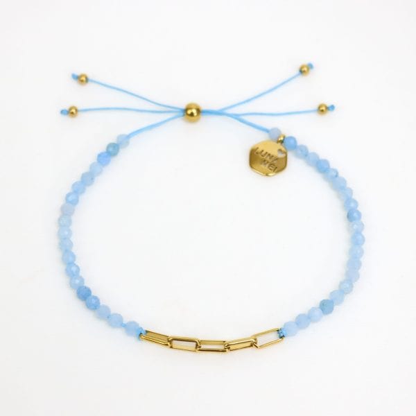 Light blue beaded bracelet with gold accents on a white background