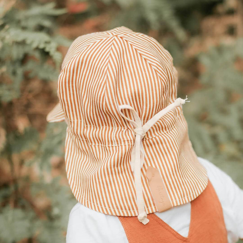 Person wearing a striped sun hat with a blurred natural background