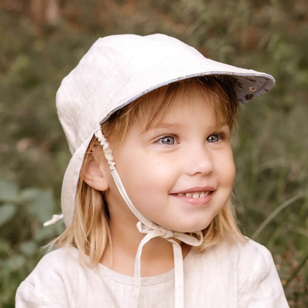 Child wearing a light-colored bonnet with a natural background