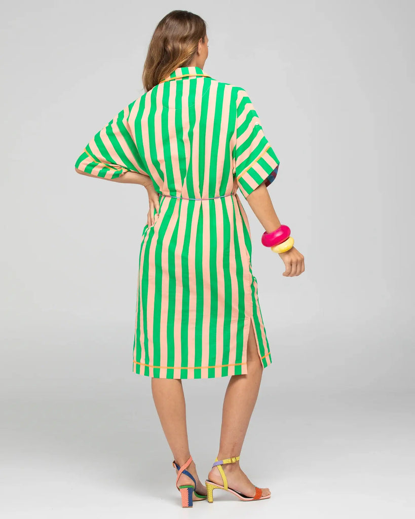 Woman wearing a green and white striped dress on a gray background