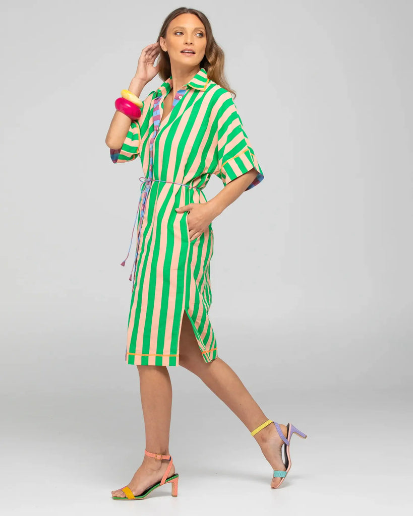 Woman wearing a green and white striped dress on a gray background