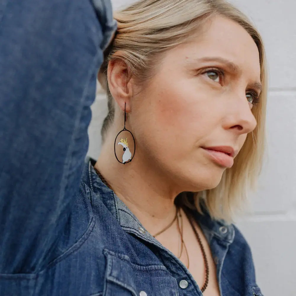 Woman wearing a denim jacket with a close-up of her earring.
