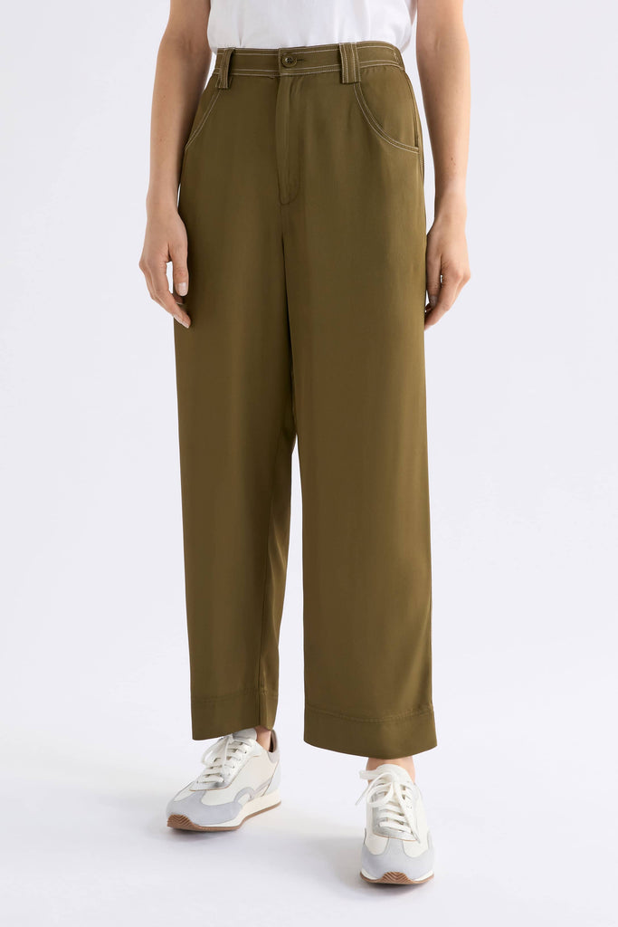 Person wearing olive green pants on a white background