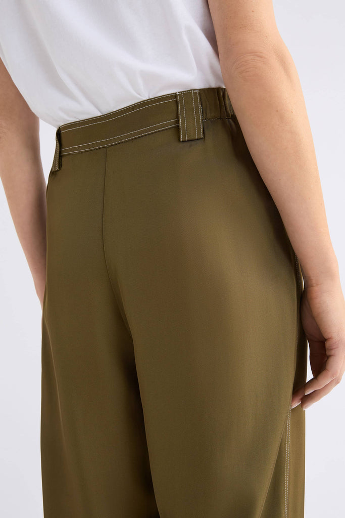 Person wearing olive green pants on a white background