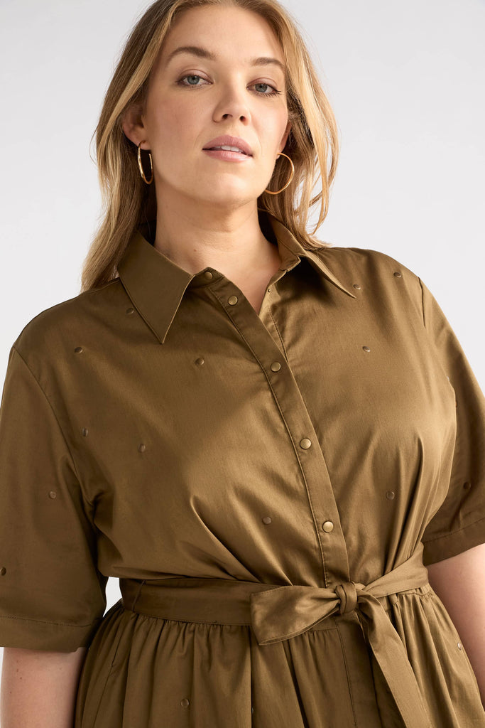 Woman wearing a brown shirt dress against a white background