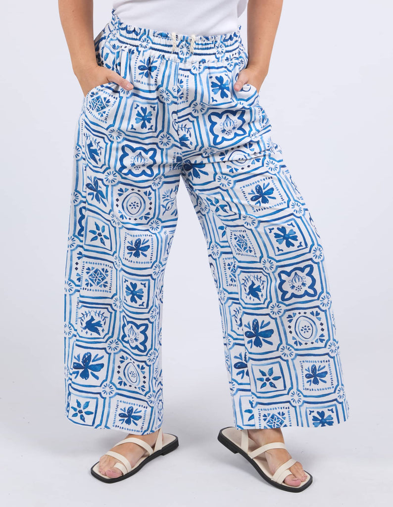 Person wearing blue and white patterned pants on a white background