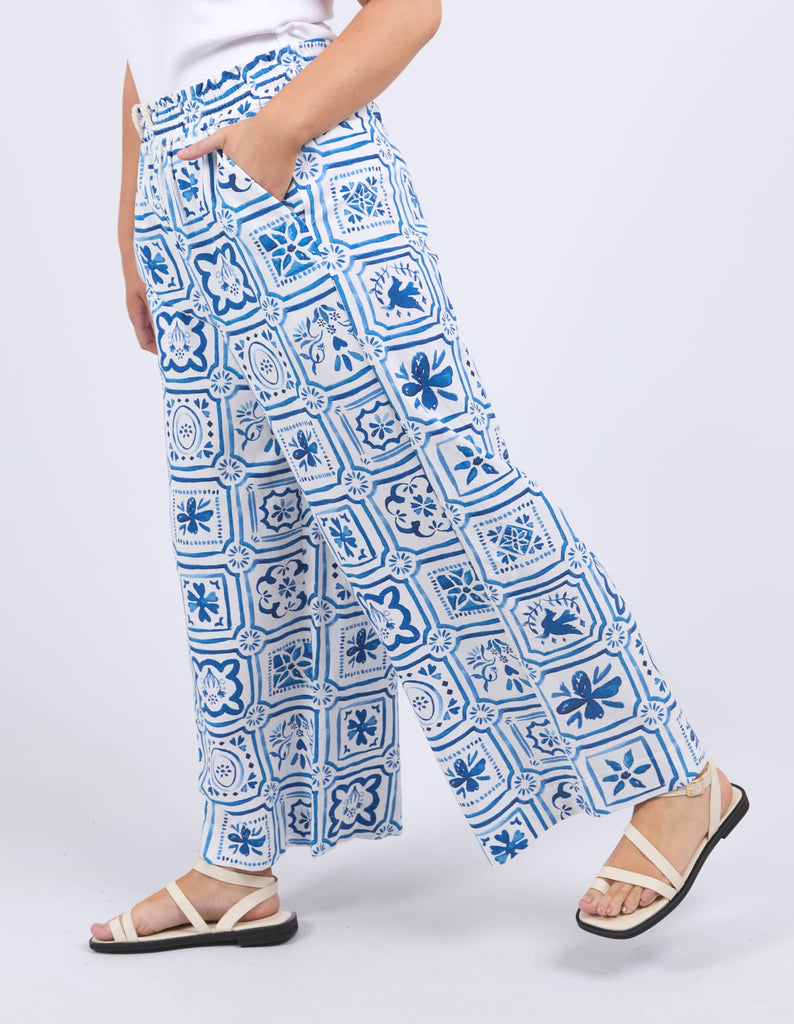 Person wearing blue and white patterned pants on a white background