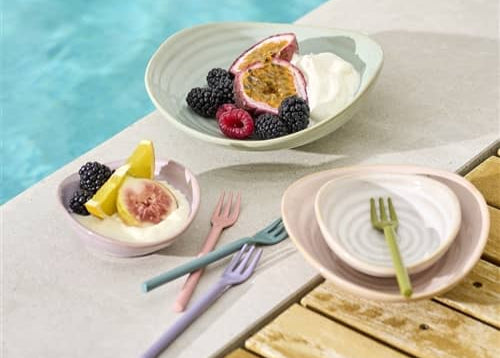 Fruit salad with yogurt on a plate by a poolside