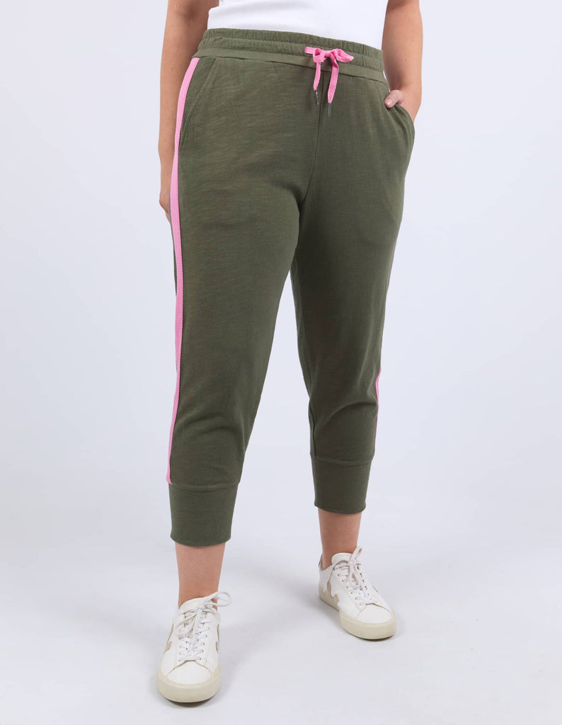 Green jogger pants with pink stripes on a white background