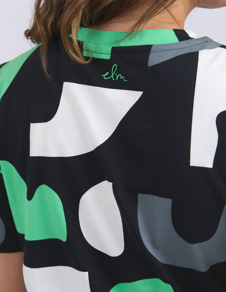 Close-up of a person wearing a colorful shirt with abstract patterns and text.