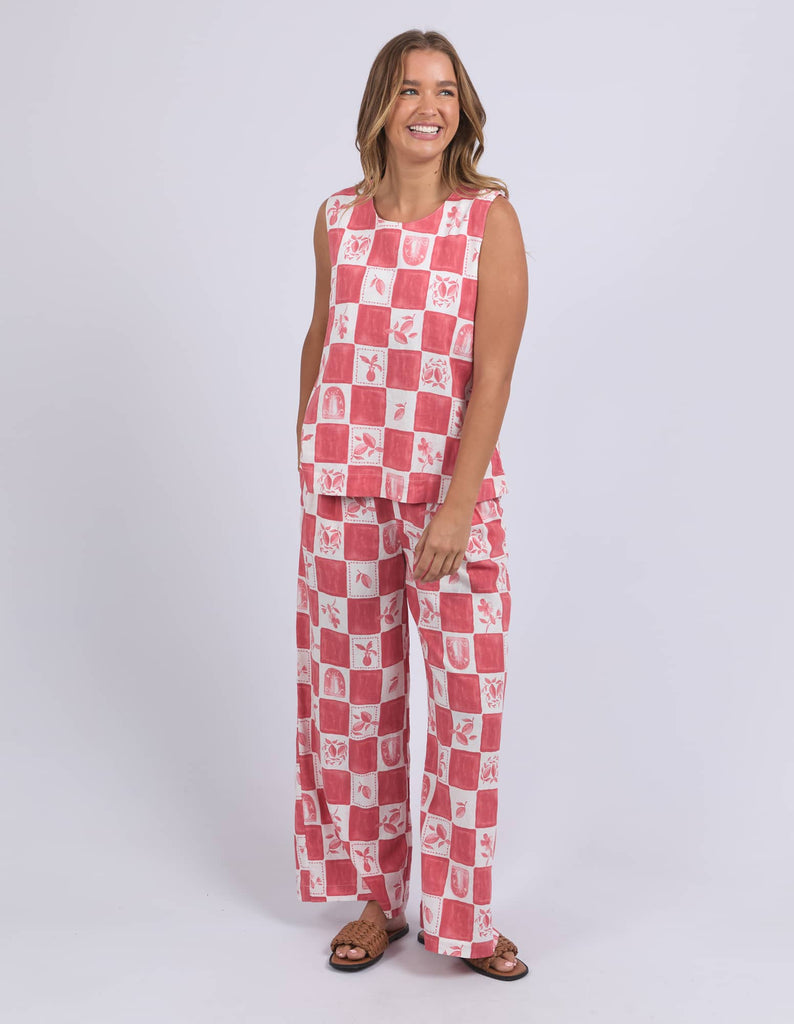 Woman wearing a red and white checkered outfit on a plain background