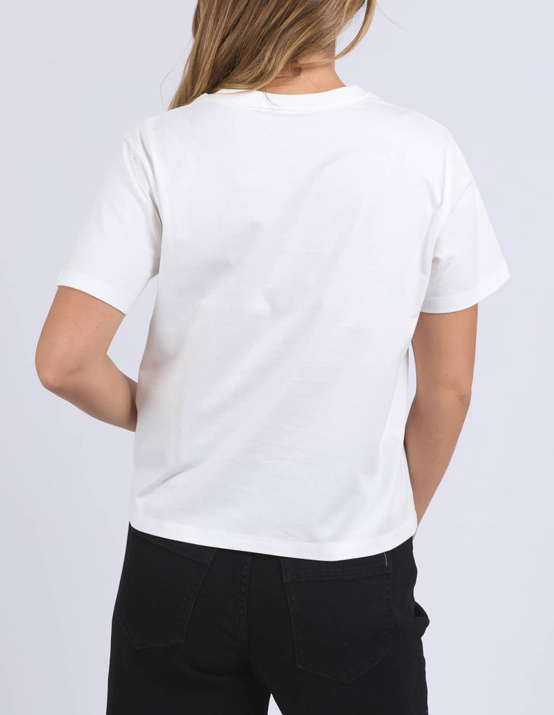 Person wearing a plain white t-shirt on a light gray background