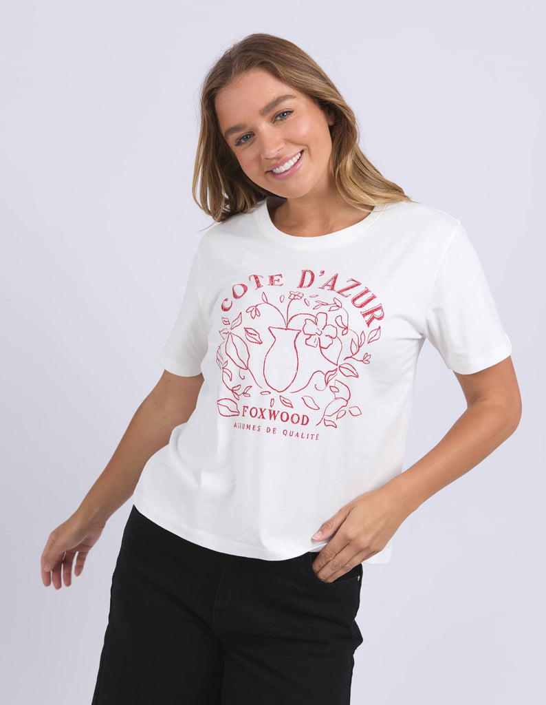 Woman wearing a white t-shirt with red text and design on a plain background