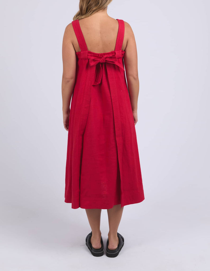 Red dress with a bow detail on the back, worn by a person on a white background