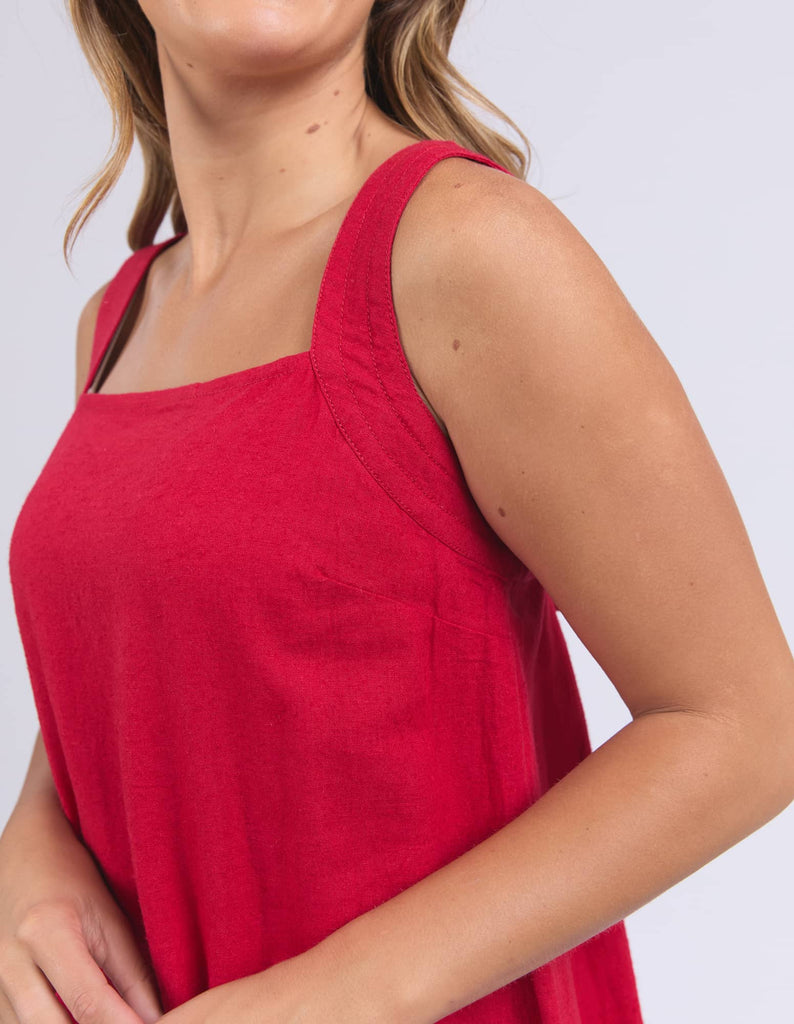 Red sleeveless top worn by a person on a plain background