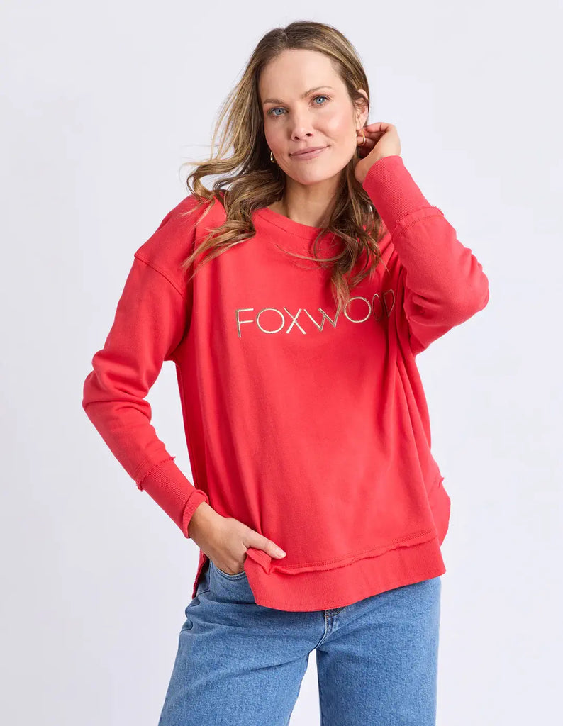 Woman wearing a red hoodie with 'FOXW' logo on a light gray background