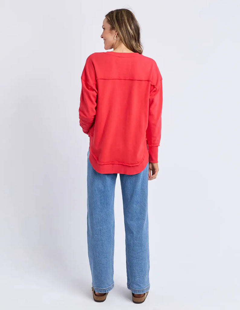 Person wearing a red sweatshirt and blue jeans on a white background