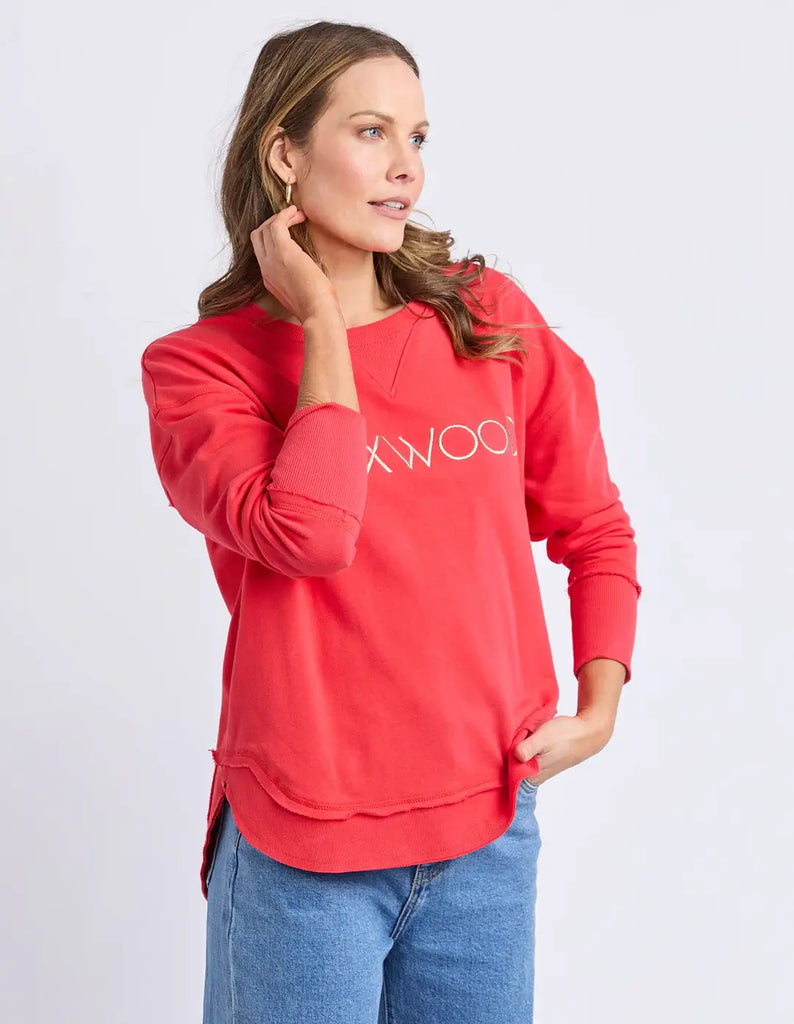 Woman wearing a red sweatshirt with 'XXWOO' branding on a light gray background
