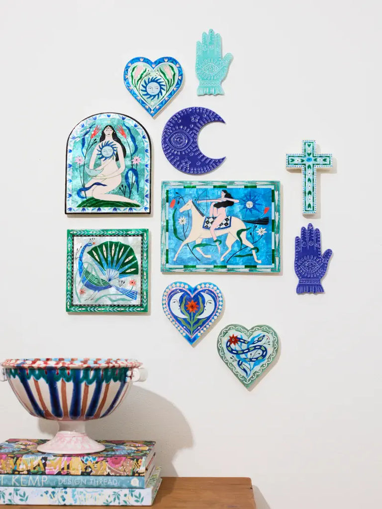 Decorative wall art pieces including colorful tiles and a bowl on a white wall.