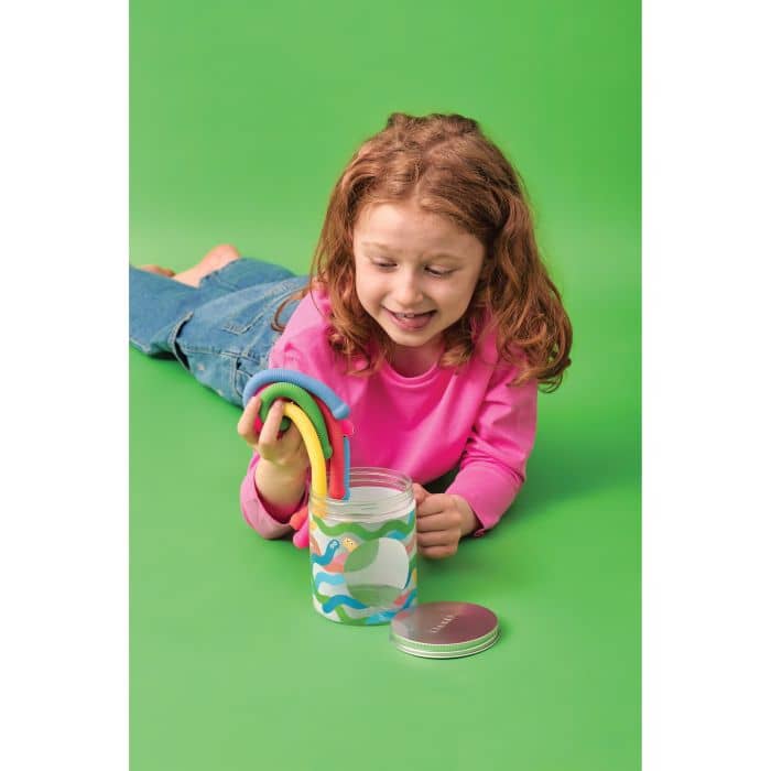 Child playing with a colorful toy on a green background