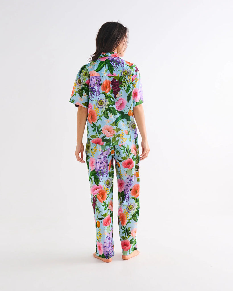 Person wearing a colorful floral pajama set on a white background