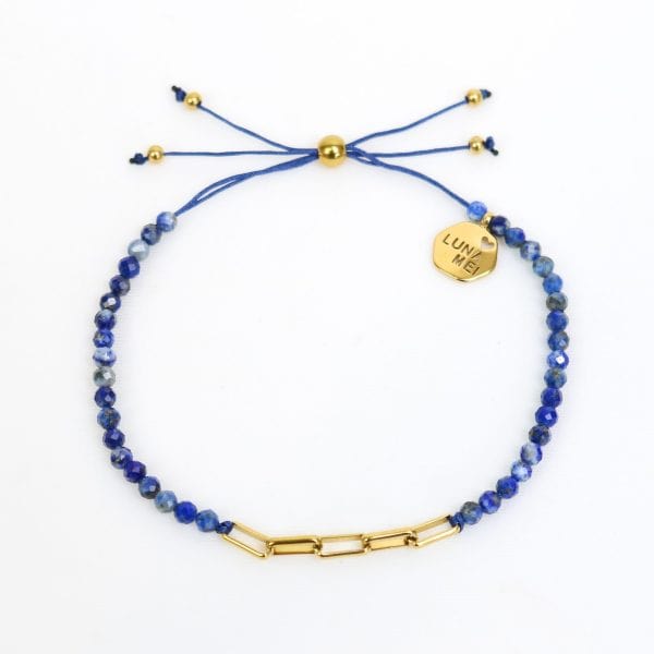 Blue beaded bracelet with gold accents on a white background