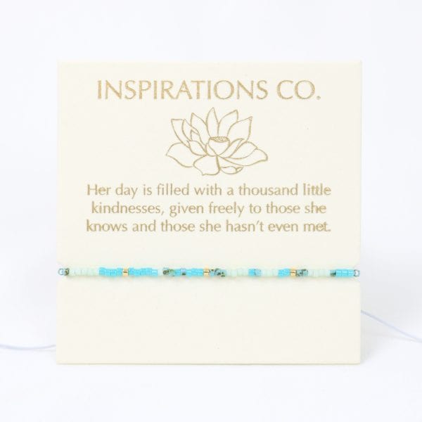 Bracelet with blue beads on a card from Inspirations Co.