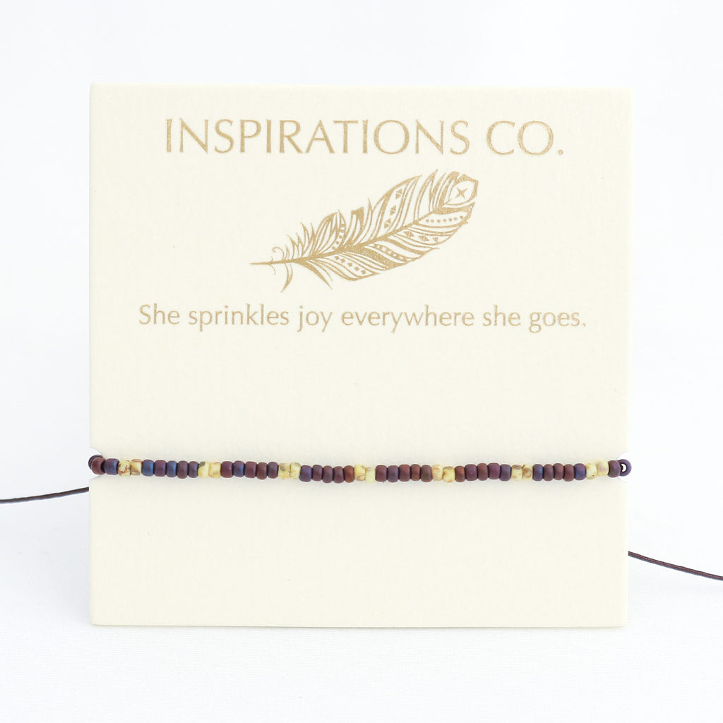 Beaded bracelet on a card with 'Inspirations Co.' branding and feather design.