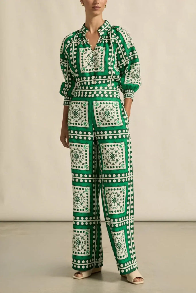 Person wearing a green and white patterned outfit on a plain background