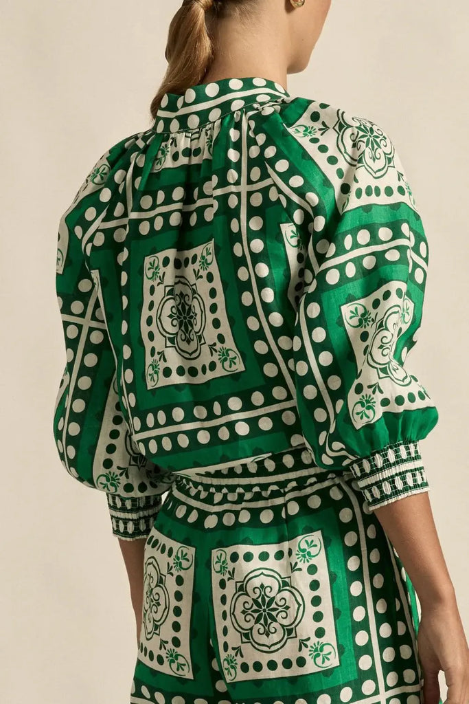 Green and white patterned outfit with a beige background