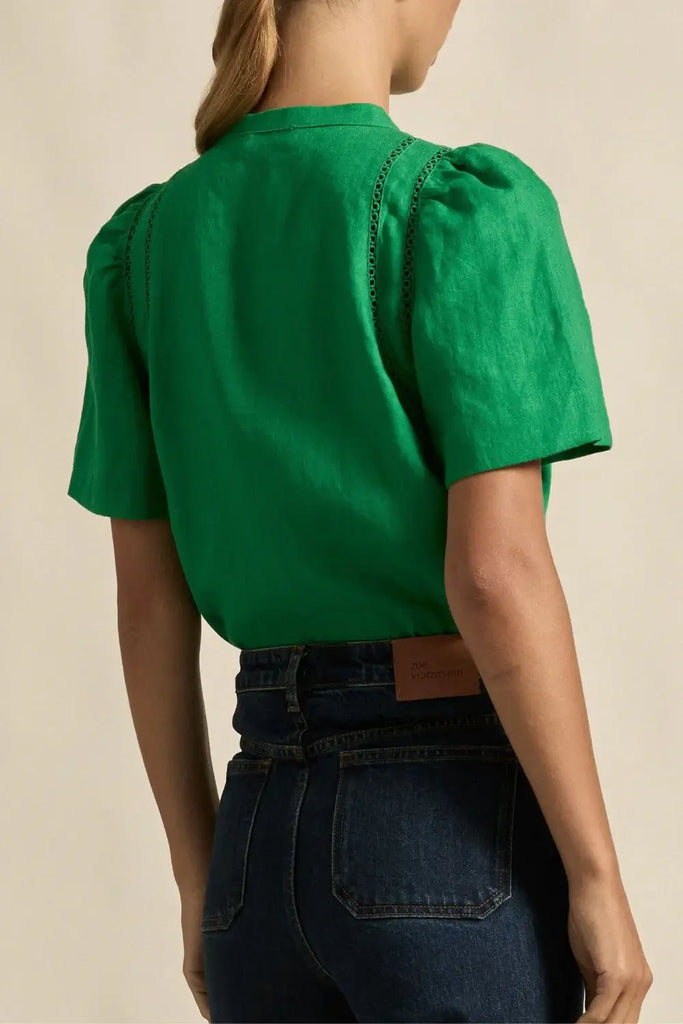 Green blouse with short sleeves and a beige background