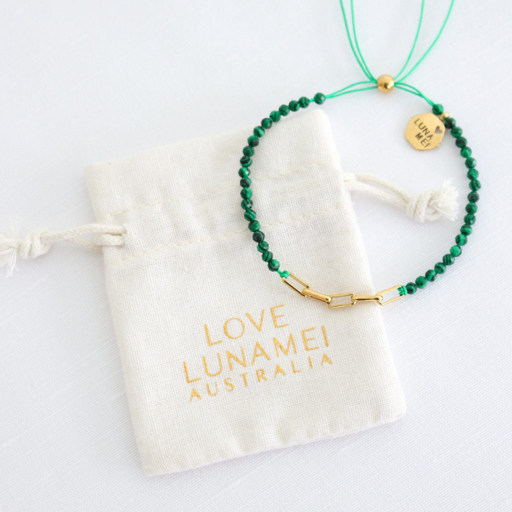 Green beaded necklace with gold clasp on a 'Love Lunamai Australia' branded pouch.