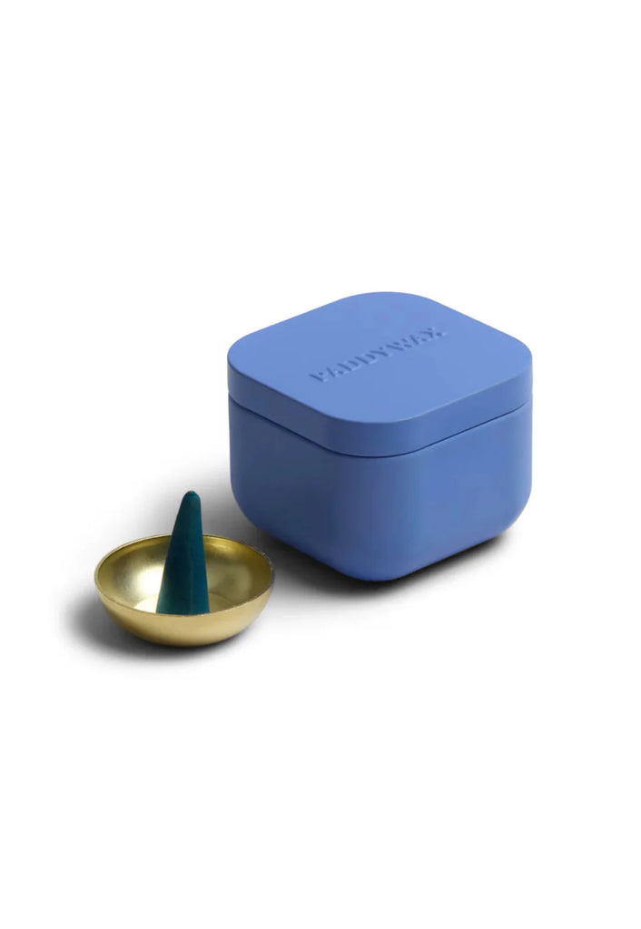 Blue incense box with a gold dish containing an incense stick on a white background