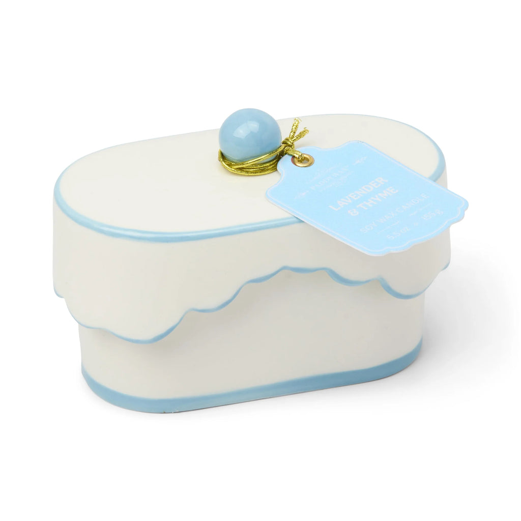 White cake-shaped container with blue accents and a blue ball on top, on a white background