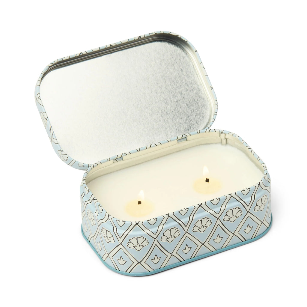 Small decorative tin with a candle inside on a white background