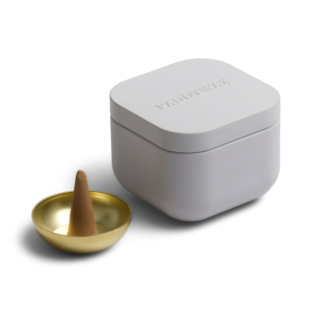 Gray incense burner with a gold bowl and brown cone on a white background