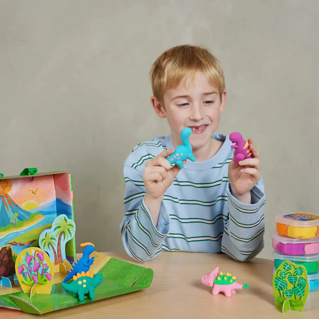 Child playing with colorful dinosaur toys on a table against a plain background