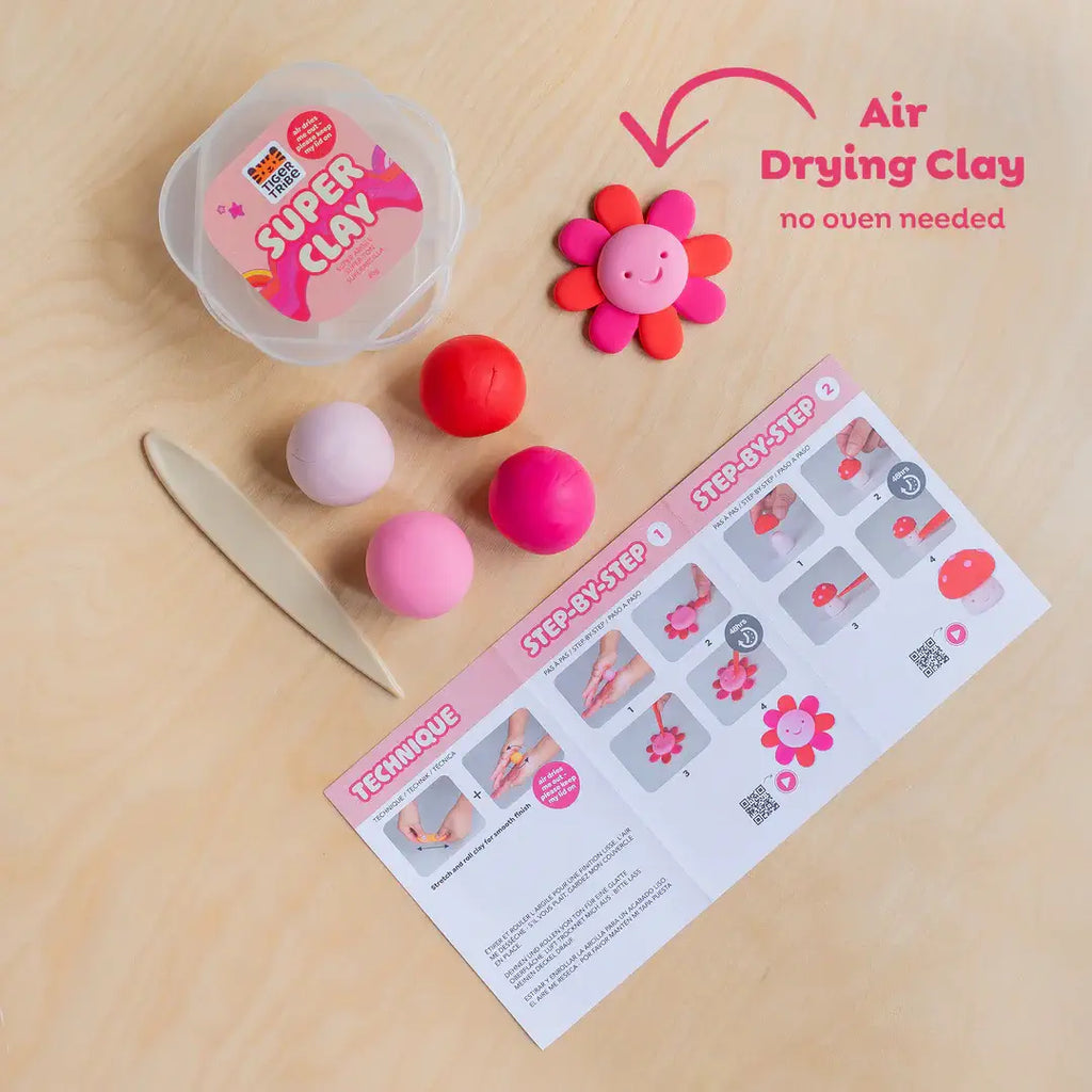 Super Clay kit with air-drying clay, tools, and a step-by-step guide on a wooden surface.