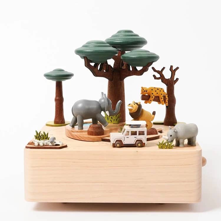 Toy safari scene with animals and trees on a wooden base