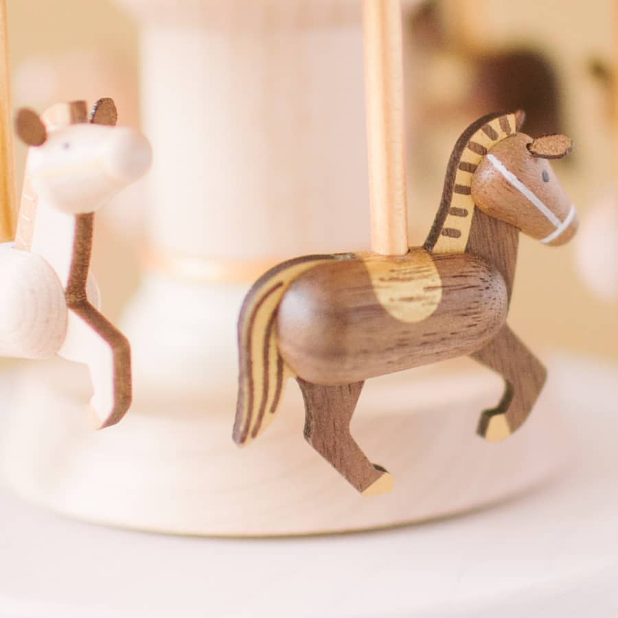 Wooden horse figurine on a white surface with a blurred background