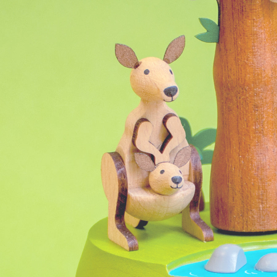 Wooden kangaroo and Joey figure on a green background with a tree and water element.