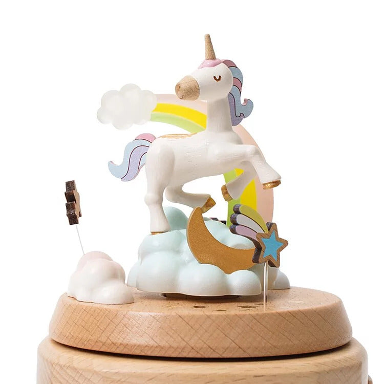 Wooden unicorn figurine on a cloud with rainbow mane, sitting on a wooden base.