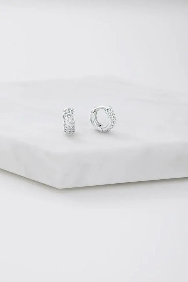 Pair of silver hoop earrings on a light gray background