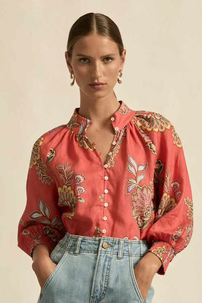 Woman wearing a red floral blouse with a beige background