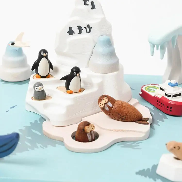Toy set with penguins, seals, and a boat on a blue surface