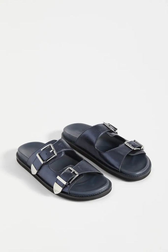 Pair of navy sandals with silver buckles on a white background