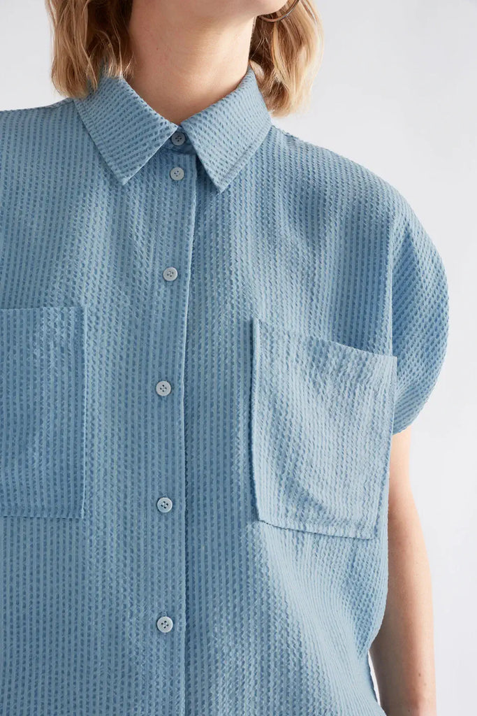 Light blue textured shirt worn by a person on a white background